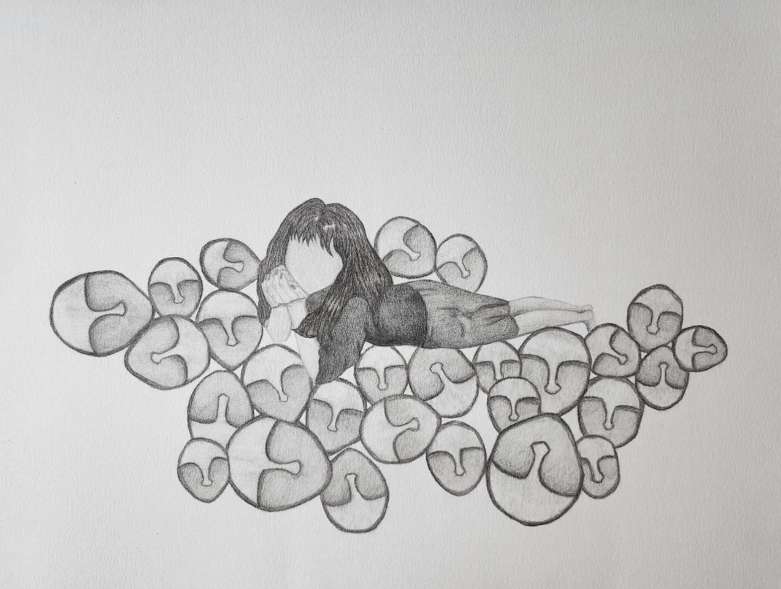 A charcoal drawing of a figure with long dark hair lying among dozens of round, faceless masks.