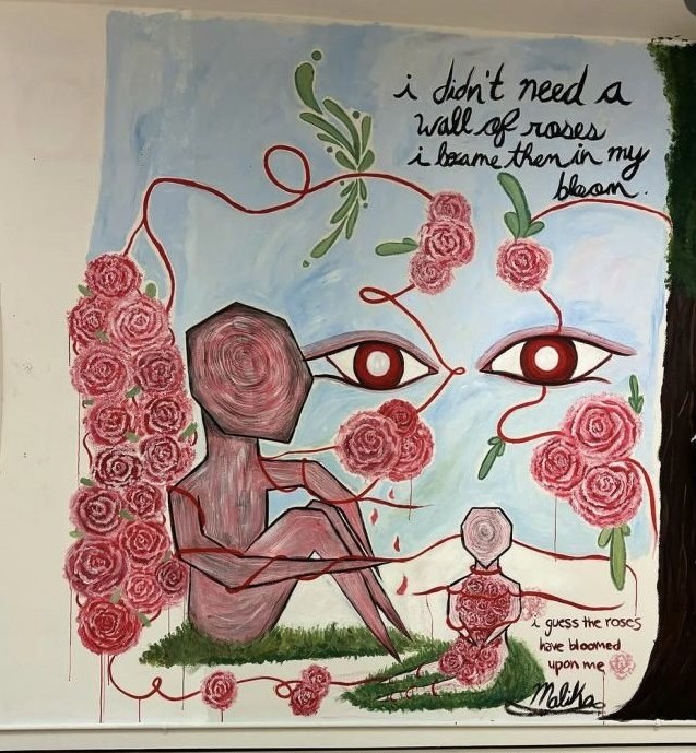 A hallway mural: a rose-hued figure beneath two watching eyes and a climbing thread of red roses.